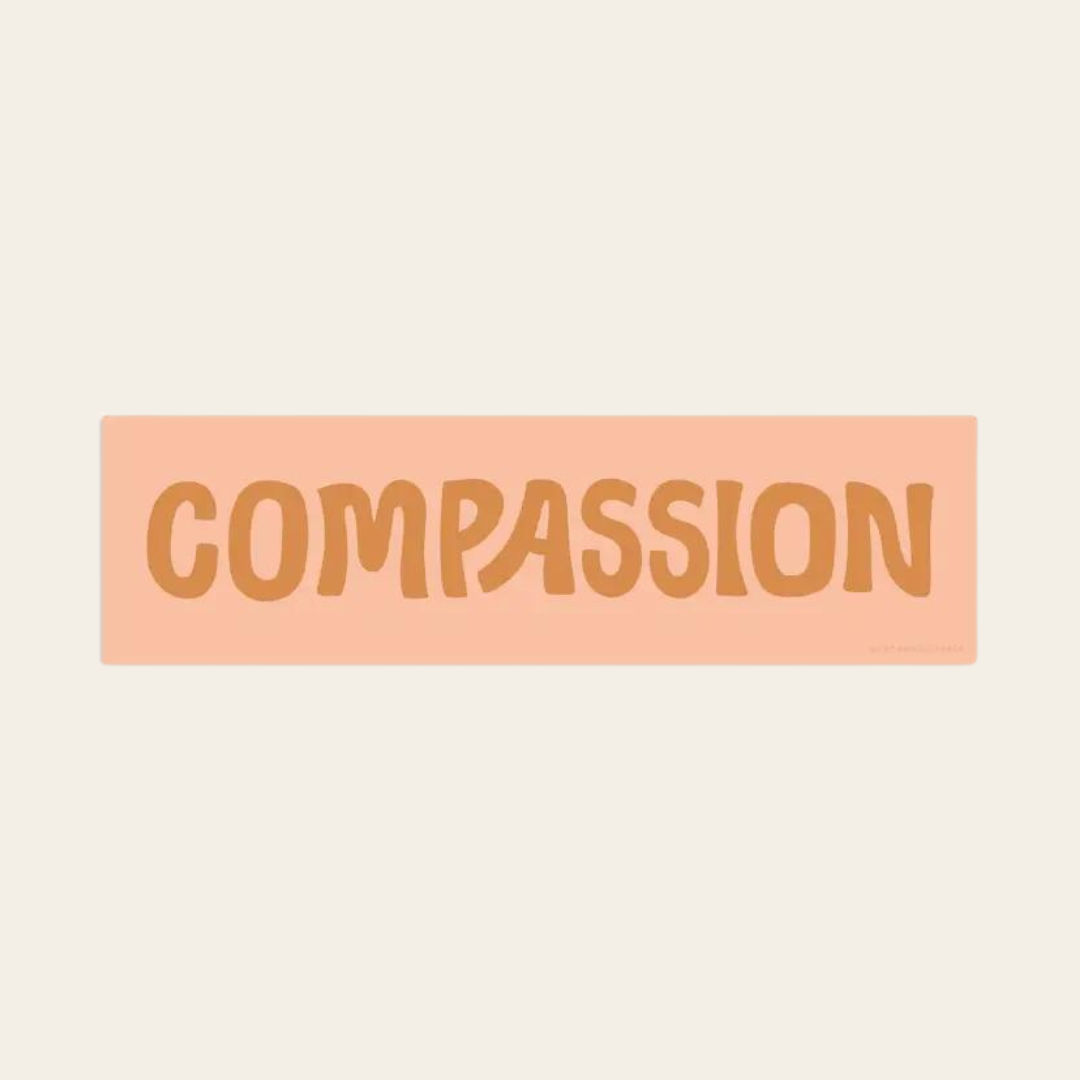 CCompassion sticker with orange text on pink background