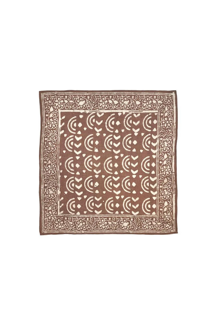 A brown bandana with half circle patterns and floral designs