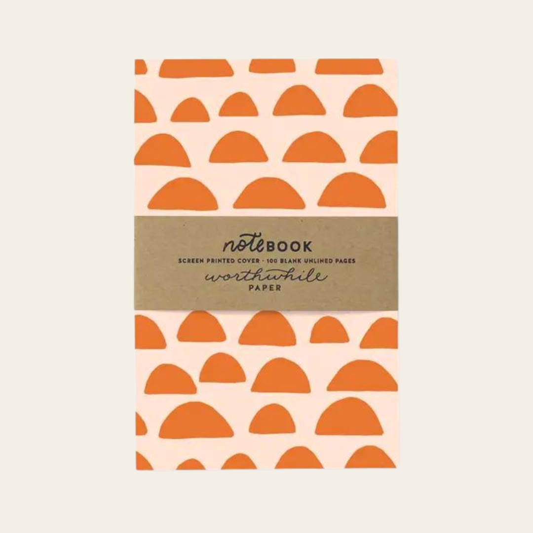 Unlined eco friendly notebook with orange half circles on a pink background