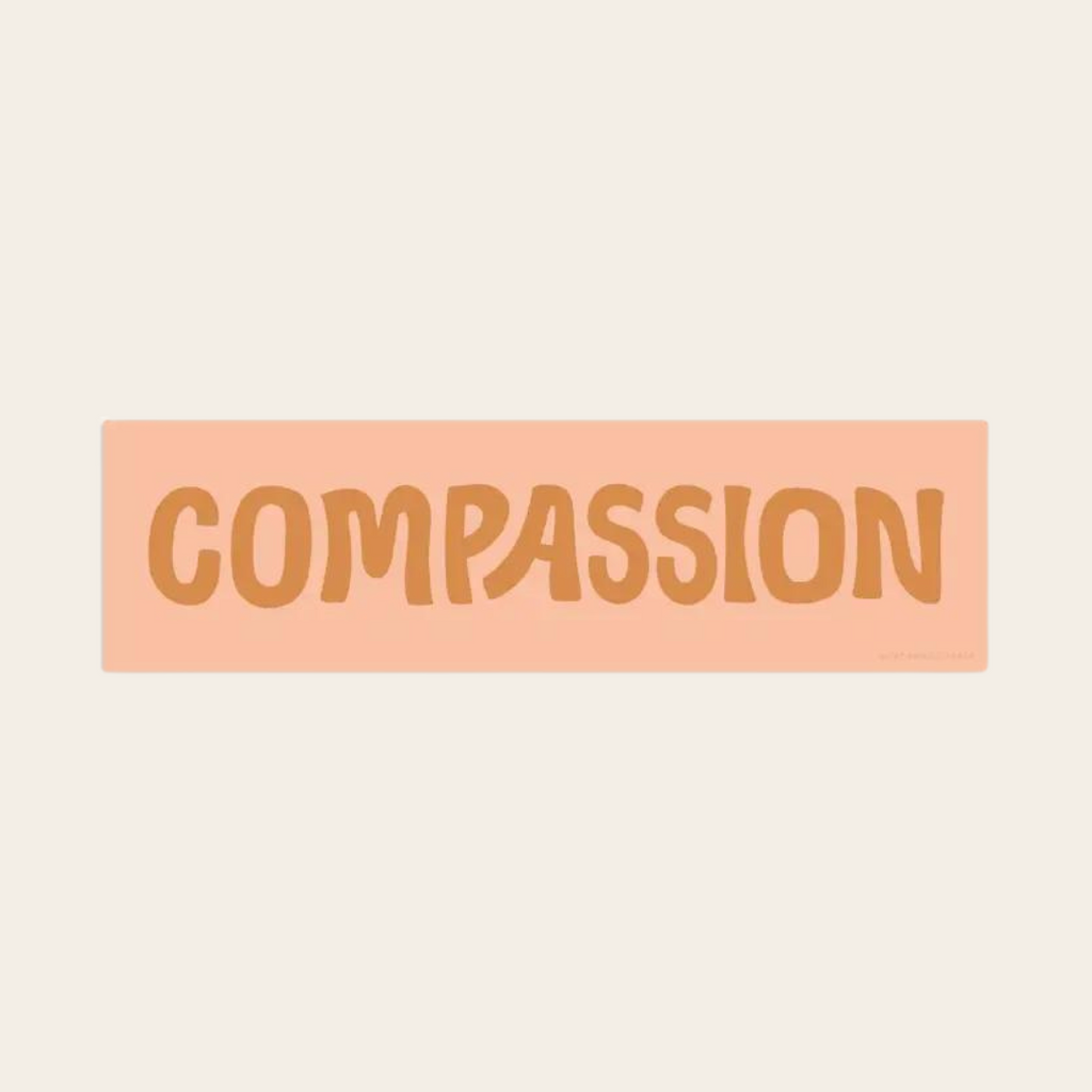 CCompassion sticker with orange text on pink background