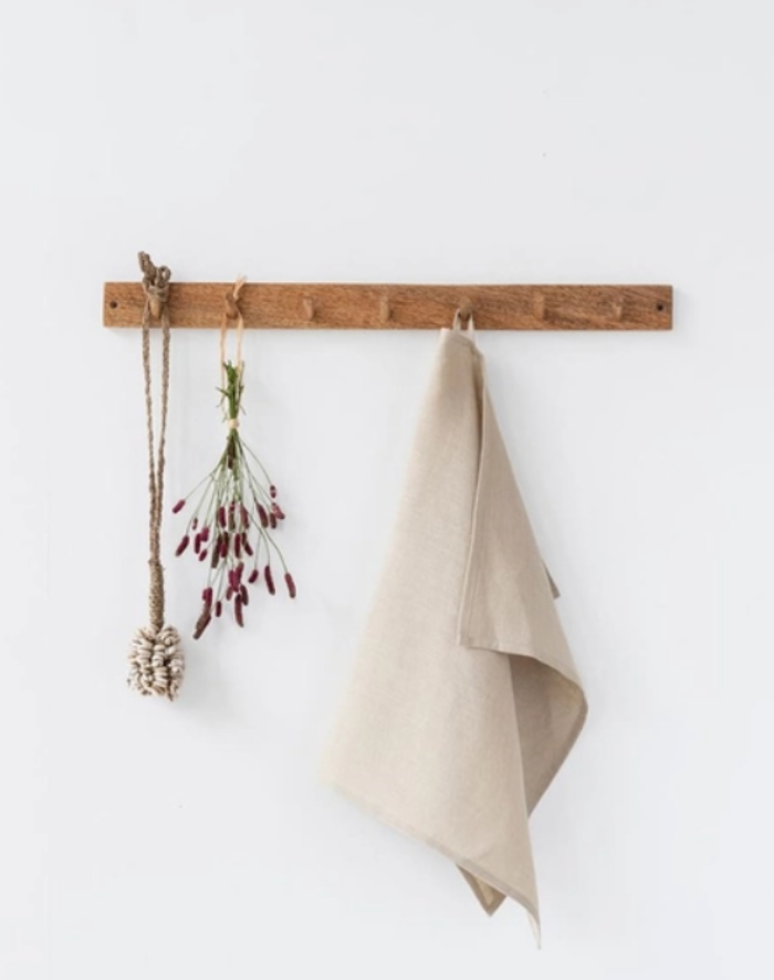 Hanging linen towel on wooden wall rack